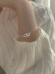 Armband mit ineinandergreifenden Herzanhängern