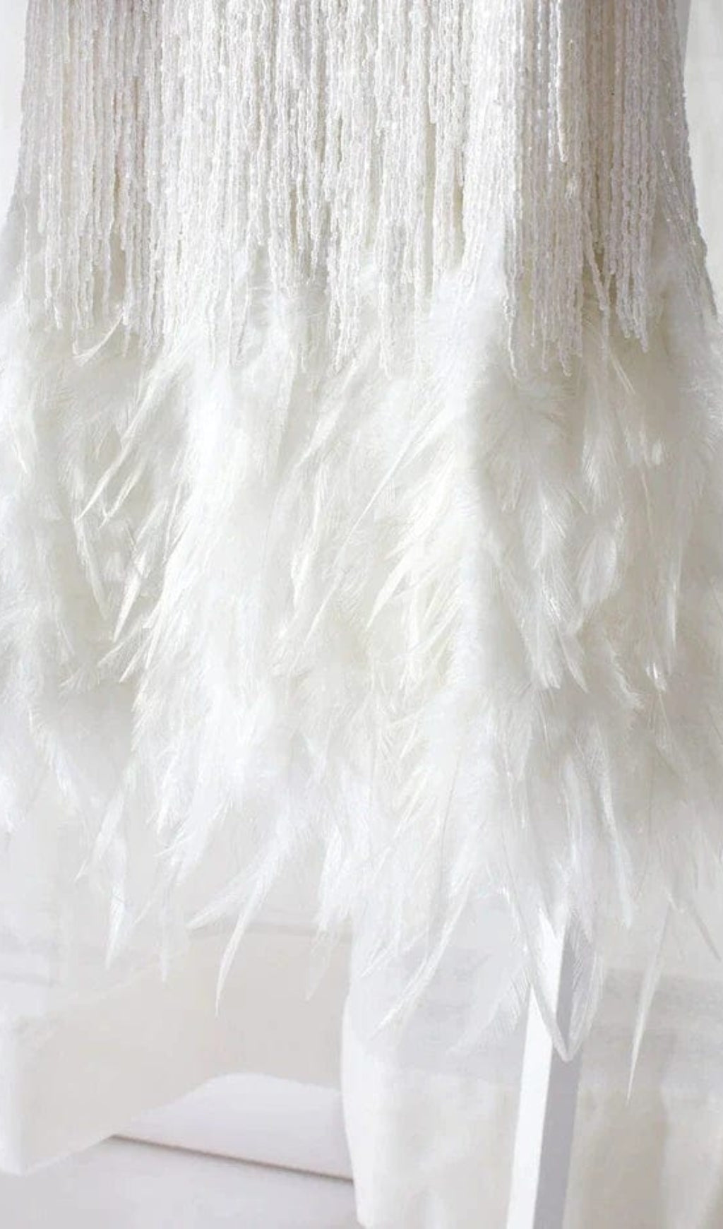 MINIKLEID MIT QUASTEN UND FEDERN IN WEISS