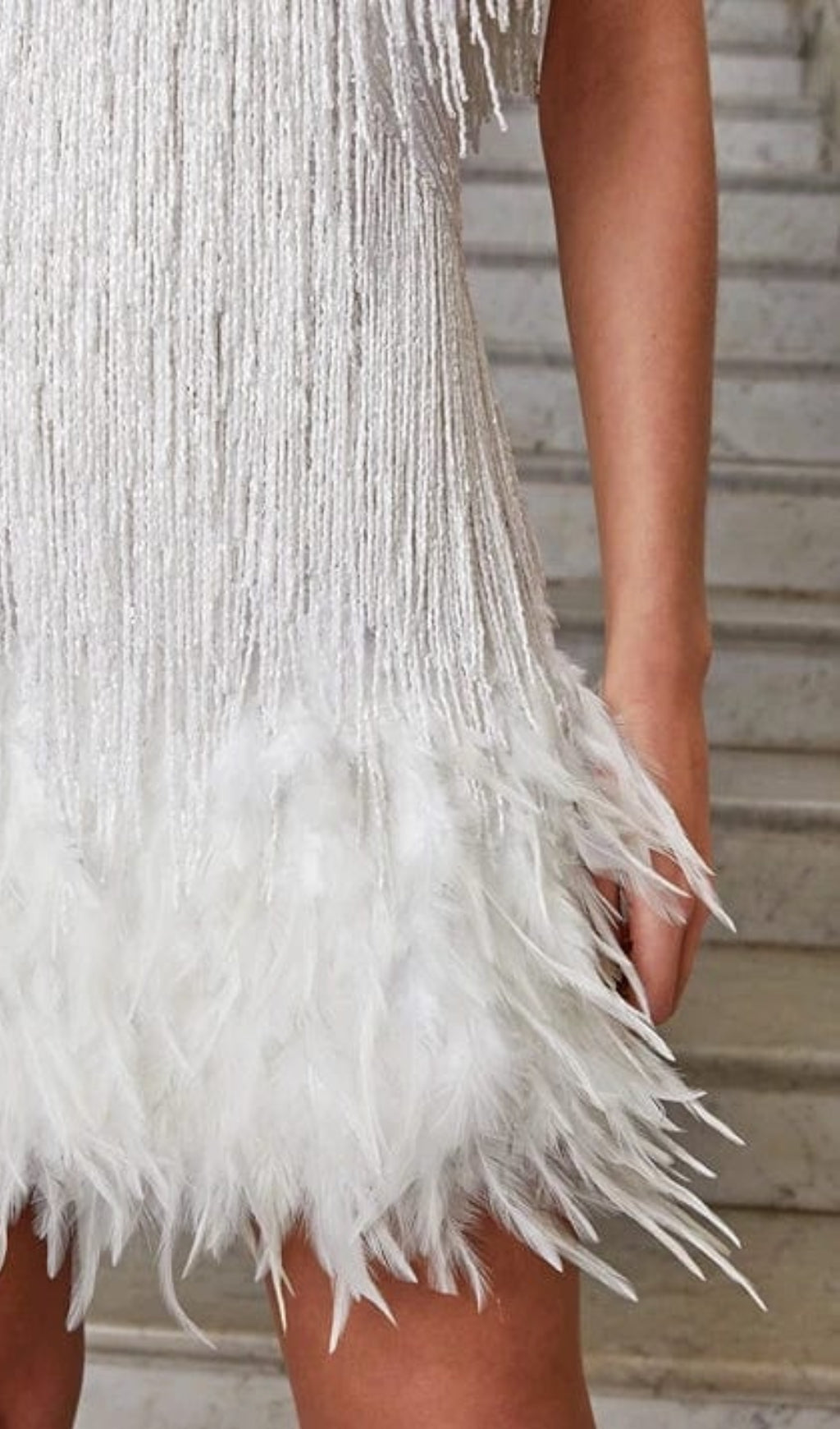 MINIKLEID MIT QUASTEN UND FEDERN IN WEISS